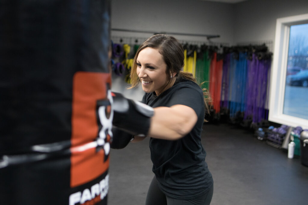 woman punching bag, kickboxing class